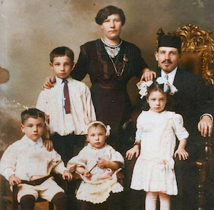 L to R: George, Hy, Helen Anna known as'Babe', mother Sarah, Rebecca, and father Rabbi Jacob Kaplan. Sarah was my grandfather's oldest sibling, daughter of Chaim and Scheina (Sadie in America) Dumes. Jacob had come to Vishki to study with a rabbi who was famous in the region, and he found room and board at the Dumes household. <br><br>Some time ago, Harry and Caroline Lieberman recorded some family history questions they posed to Babe Kaplan Bennett on a cassette, and so I was able to transcribe some of her stories, such as this one. Babe said it was a great honor for them to have a student. And before too long, Jacob and Sarah were married. 