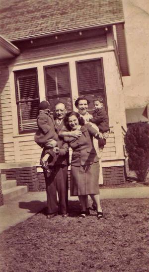 Louis Dumes, Evelyn Dumes, Rebecca Dumes holding Rick Dumes, Mike Dumes in Louis' arms.  Taken in Vincennes, IN front of William Dumes home.
 (about 1945)