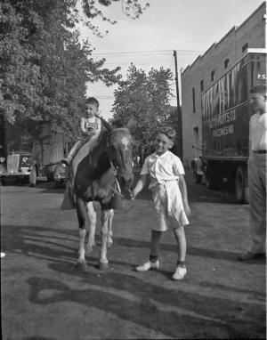 Melvin Shapiro on Nellie, Stan Dumes' pony.  Stan Dumes standing on right.

 (~1936)